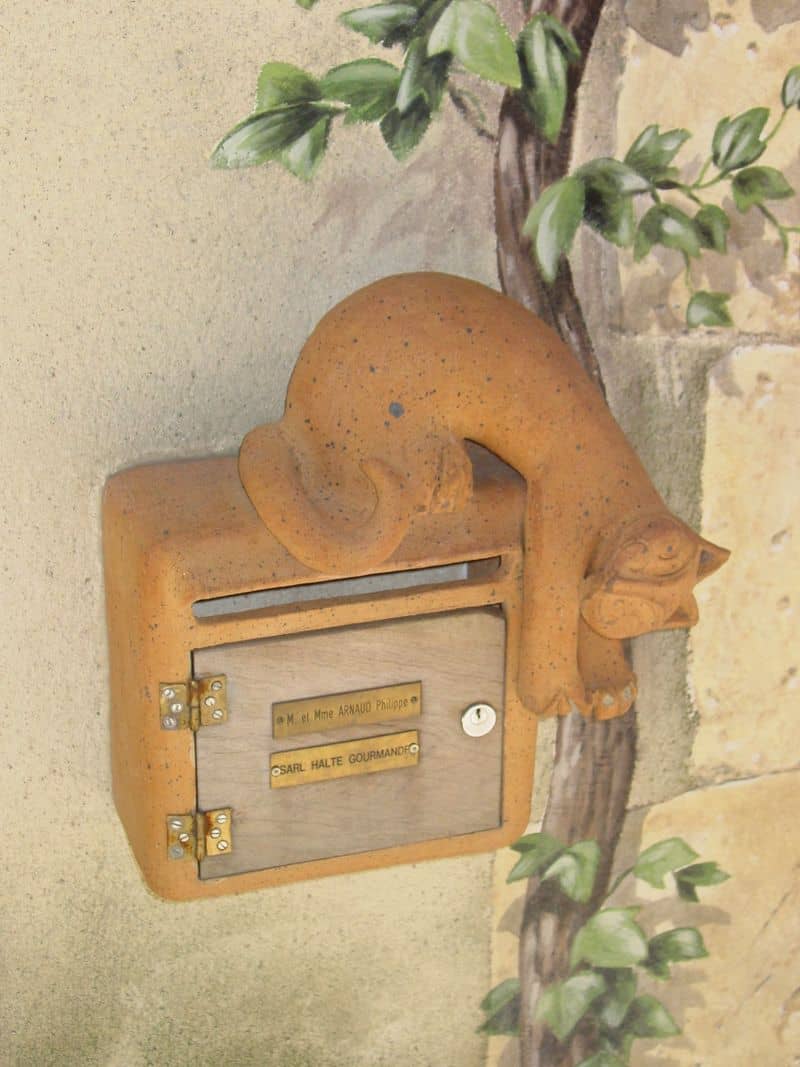 A not so ordinary mailbox with a playful kitty daring you to put the mail in.